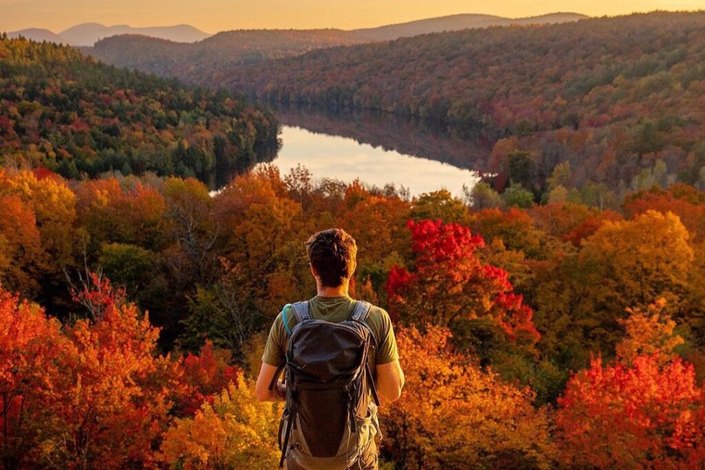 Randonneur devant le lac et la forêt d'automne des Cantons-de-l'Est